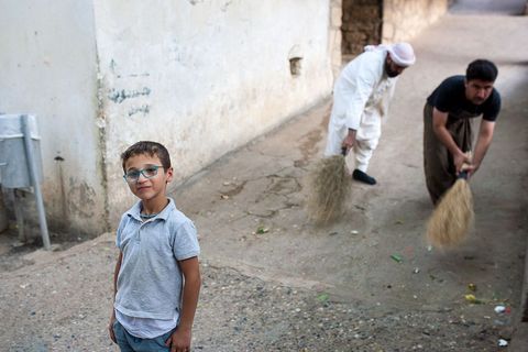 Mali Jezid na ulicama svetog grada Lališa, kojeg stariji ritualno čiste iza njegovih leđa